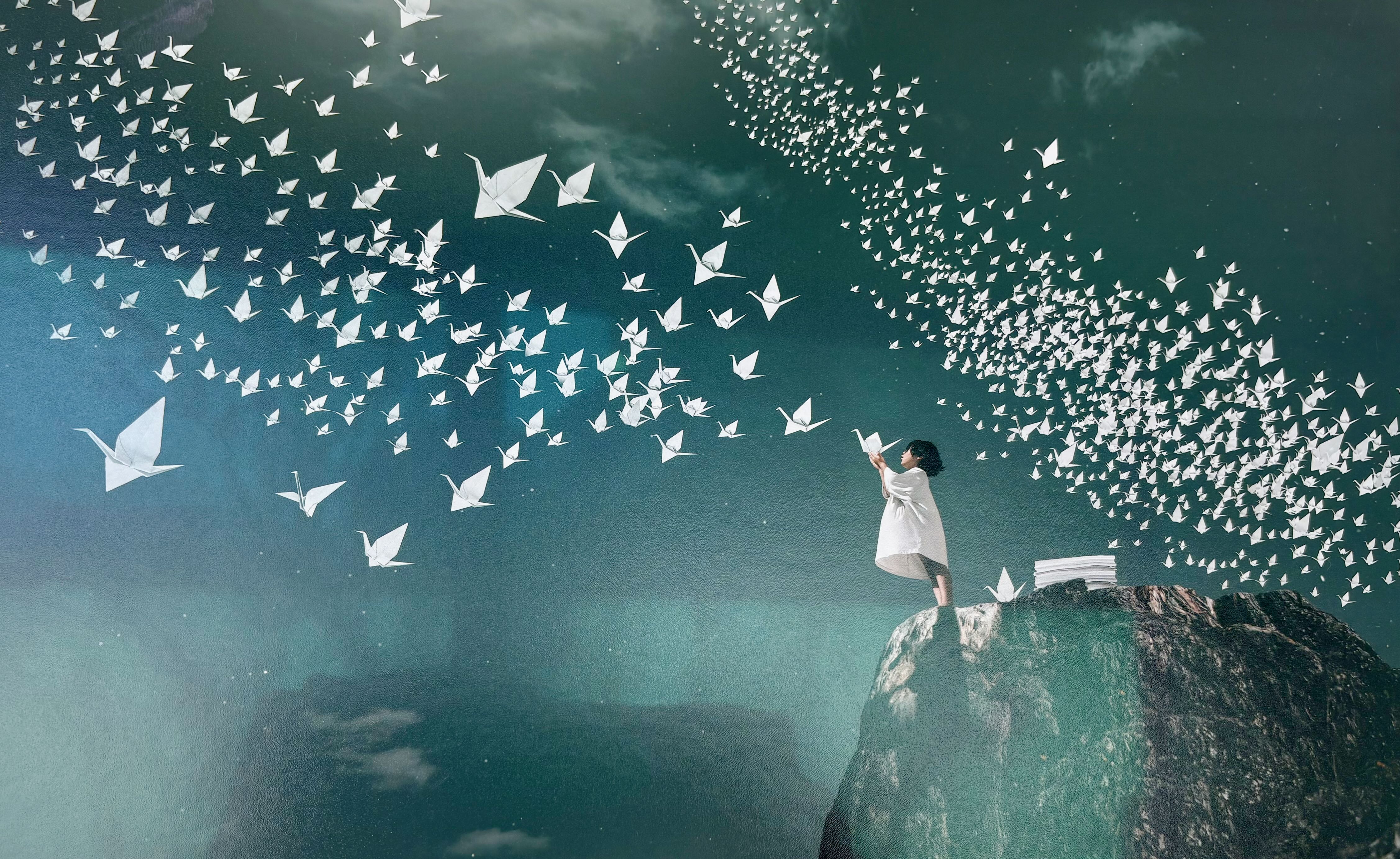 Photo symbolique d’un enfant face à une envolée d’oiseaux en papier